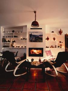 a living room with chairs and a table and a fireplace at Casa El Rincón del Guardal in Huéscar