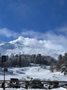 a snow covered hill with a mountain in the background at La capannetta house in Castiglione di Sicilia