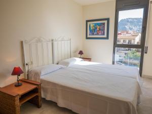 1 dormitorio con 2 camas blancas y ventana en Agi Riera Ginjolers, en Roses
