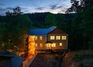 a house on a hill with its lights on at Sweet Escape By Ghosal Luxury Lodging in Gatlinburg