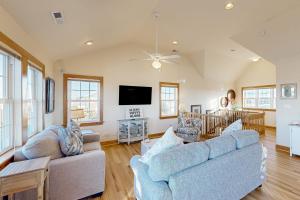 a living room with two couches and a tv at Pamlico Paradise 634 in Waves