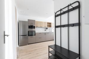 a kitchen with stainless steel appliances and wooden floors at Elégance en Luberon - 4 personnes - Central - Wifi in Apt +13 photos