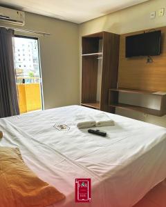 Schlafzimmer mit einem Bett mit Fernbedienung in der Unterkunft Hotel dos Reis in Belém