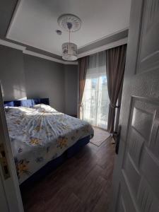 a bedroom with a bed with a floral comforter and a window at villaLemoon in Belek +70 photos
