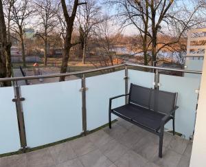 a black chair sitting on top of a balcony at Apartament Tomek in Iława