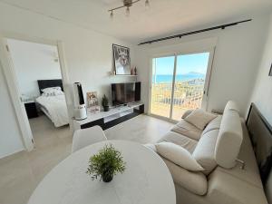 a white living room with a couch and a table at Perfect Flat with Ocean Views in Valencia in Miramar