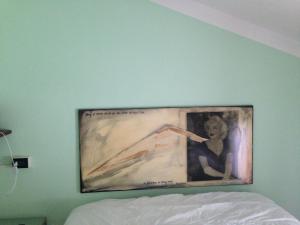 ein Bild einer Frau an einer Wand über einem Bett in der Unterkunft B&B La Corte in Vigolzone