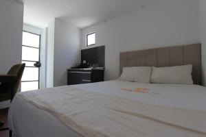 Cama ou camas em um quarto em Wafeh Pampulha Suítes