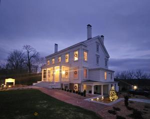 a large white house with a christmas tree in the yard at Peach Grove House in Warwick