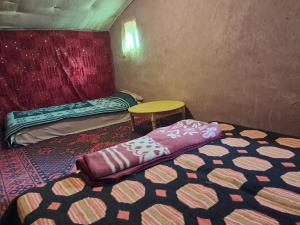 a small room with a bed and a table at Camp Sahara inspiration in Mhamid