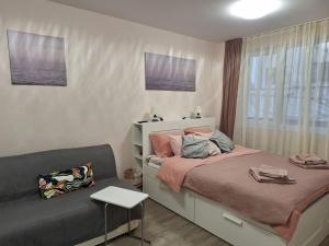 a small bedroom with a bed and a couch at Апартамент Квадратчето in Vratsa +8 photos