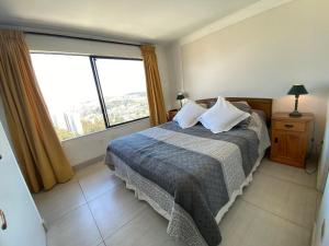 a bedroom with a bed and a large window at Casa Familiar en Jardín del Mar in Viña del Mar +19 photos