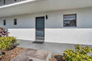 a white building with a blue door on it at Walk From Lanai to Pool and More in Naples
