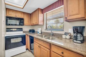 a kitchen with a sink and a stove at Walk From Lanai to Pool and More in Naples