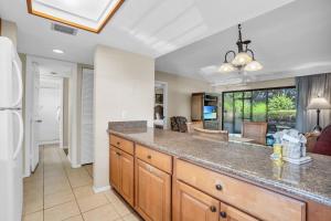a kitchen with a large counter and a dining room at Walk From Lanai to Pool and More in Naples