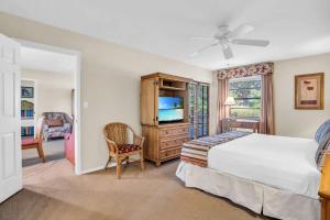 a bedroom with a bed and a dresser with a tv at Walk From Lanai to Pool and More in Naples