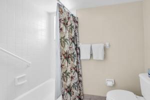 a bathroom with a shower curtain and a toilet at Walk From Lanai to Pool and More in Naples