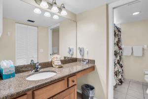 a bathroom with a sink and a mirror at Walk From Lanai to Pool and More in Naples