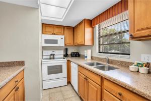 a kitchen with wooden cabinets and white appliances at First Floor Deluxe Condo in Naples