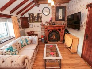 ein Wohnzimmer mit Couch und Kamin in der Unterkunft The Old Mill Cottage in Whitby