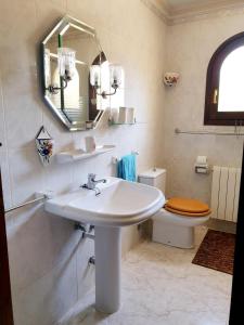 a bathroom with a sink and a toilet and a mirror at "Traumhaftes Ferienhaus mit Pool und Meerblick - Cumbre del Sol erleben!" in Benitachell