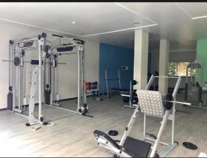 a gym with several machines and a chair in a room at Summer Beach 300 mt da praia com amplo lazer e mobília nova in Bombinhas