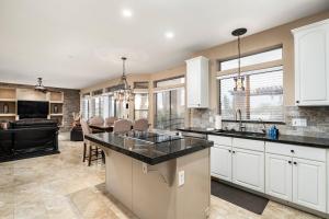 a kitchen with white cabinets and a dining room at Pinnacle Perfection by Porter Heated Pool Spa w Outdoor Putting Green in Scottsdale