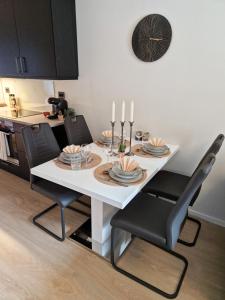 una mesa de comedor blanca con sillas negras y velas en New&cozy apartment near Vrådal Panorama Ski Resort, Golf and Beach, en Vradal