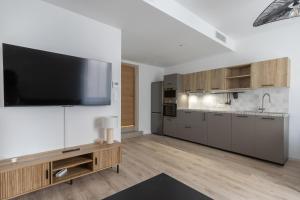 a large kitchen with a flat screen tv on a wall at Elégance en Luberon - 4 personnes - Central - Wifi in Apt