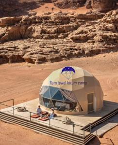 zwei Menschen sitzen in einem Zelt in der Wüste in der Unterkunft Buble camp tour in Disah