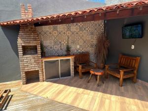 a patio with two chairs and a fireplace at chalé encanto dos milagres in São Miguel dos Milagres