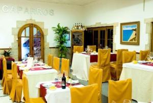 a restaurant with white tables and yellow chairs at Hotel Donde Caparrós in Carboneras