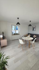a living room with a table and chairs and a couch at PRADA Apartament Konin in Konin