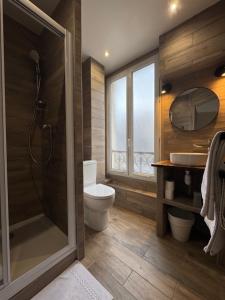 a bathroom with a shower and a toilet and a sink at Angleterre Hotel in Paris