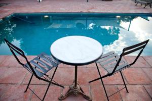 a table and two chairs next to a swimming pool at Mas del Molí in Reus
