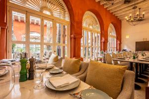 une salle à manger avec tables, chaises et fenêtres dans l'établissement Casa Pestagua Relais Châteaux, à Carthagène des Indes