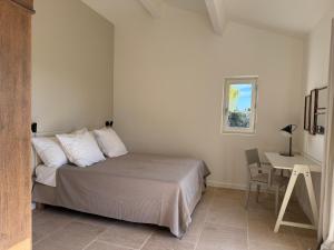 a bedroom with a bed and a table and a desk at EcoLodge romantique proche Lourmarin Piscine Privée Borne recharge in Puyvert