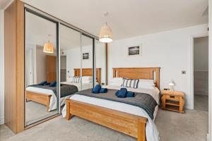 サンダースフットにあるMaes-Y-Berllan - Close to Village and Beachのベッド2台と大きな鏡のある寝室