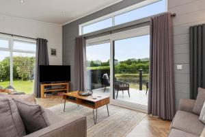 una sala de estar con una gran puerta corredera de cristal en The Duck Pond - Countryside Hot Tub, en Narberth
