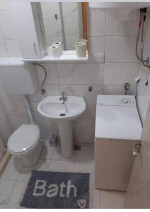 a small bathroom with a sink and a toilet at Apartmani LaVa igalo 1 in Igalo +13 photos