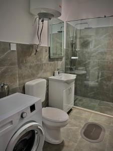 a bathroom with a toilet and a washing machine at Palma in Kamenari +19 photos