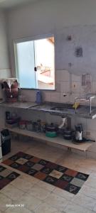 une cuisine avec un évier et une fenêtre dans l'établissement Kitnet Cabo Frio 10, à Cabo Frio