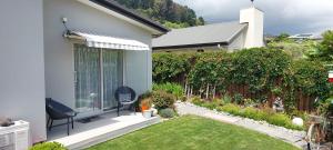 a white house with a yard with a fence at Grampians B&B in Nelson