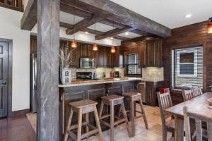 une cuisine avec des placards en bois et un bar avec des tabourets dans l'établissement Chalets Resort Luxury Lakefront Villa Family Friendly 2 Pools Free Amenities, à Lampe