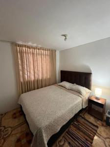 a bedroom with a large bed and a window at Palmeras house in Ica