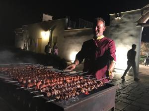 a man is cooking chickens on a grill at Relais Masseria della Colomba - Agriturismo in Francavilla Fontana