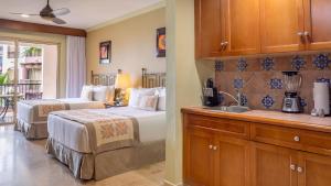a bedroom with two beds and a kitchen with a sink at Villa del Arco Beach Resort & Spa in Cabo San Lucas +50 photos