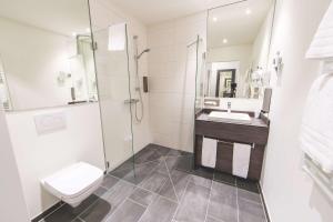 ein Badezimmer mit Toilette, Waschbecken und Dusche in der Unterkunft PLAZA INN Mannheim in Mannheim