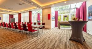 a conference room with a table and red chairs at Best Western Plus Hotel Stadtquartier Haan in Haan +64 photos