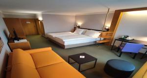 a hotel room with a bed and a couch at Best Western Parkhotel Brehna-Halle in Brehna